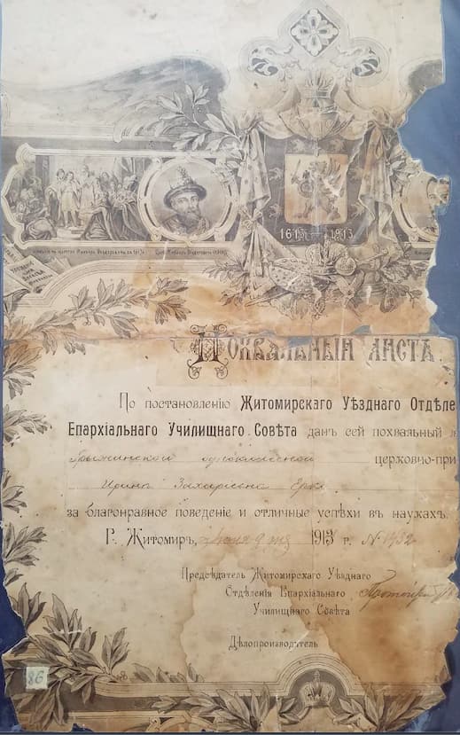 Похвальний лист 1913 року з гравюрою вгорі й ім’ям, вписаним від руки; папір пошкоджений, у плямах